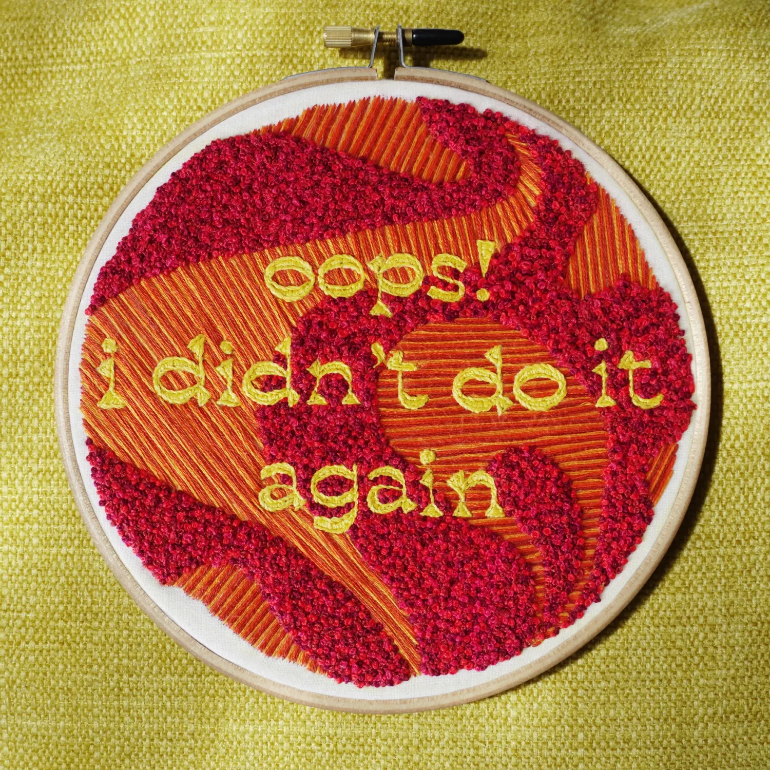 Embroidered hoop with a stitched phrase, "oops! i didn't do it again"